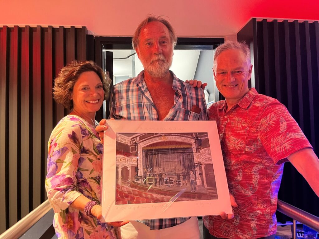 Spatz holding a painting of the theatre